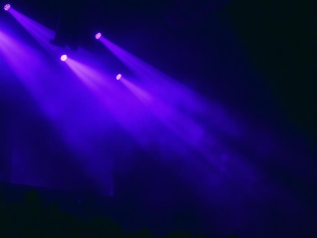 Stage lighting cutting through haze in a dark venue